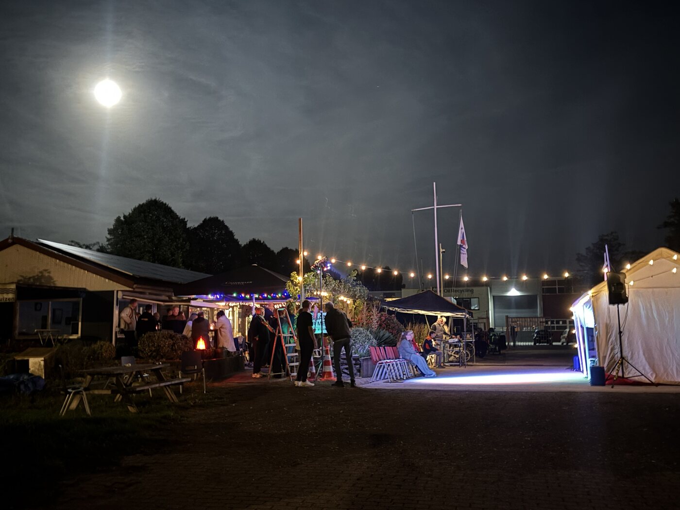 Leden genieten van een gezellige zomeravond op de haven, met verlichting en muziek